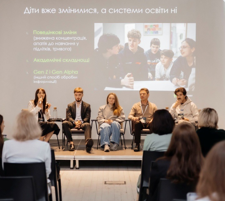 Panel discussion at a DFE event: speakers on stage with an audience, and a presentation on the screen behind them